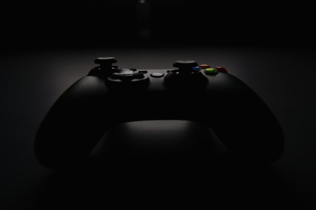 Fotografia real de um comando Xbox escuro sobre fundo preto